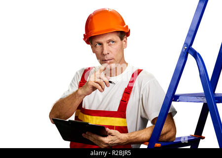 Thoughtful foreman on white background. Handsome middle-aged building engineer in helmet with folder over white background. Supervisor checking an obj Stock Photo