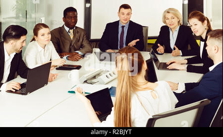 coworkers of different nationalities developing strategy for teamwork in modern office Stock Photo
