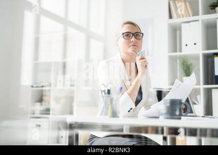 Pensive lady working with papers in office Stock Photo