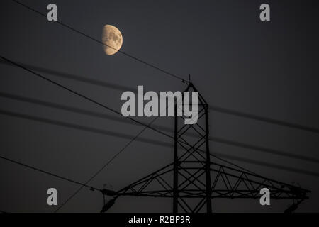 A electrical pylon pictured with a beautiful Moon in the background Stock Photo