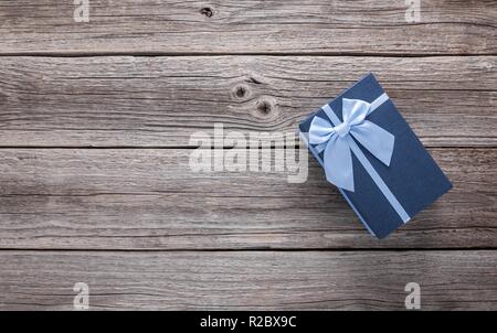 Stylish gift box on the background of wooden boards. Stock Photo