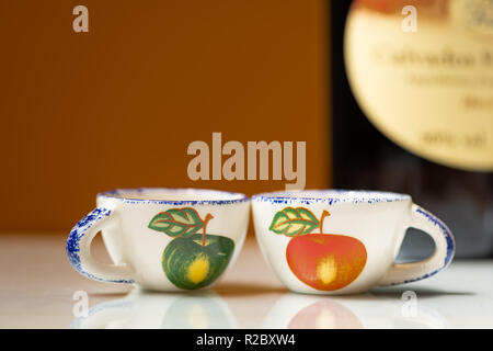 Closeup of two small cups with painted apples for drinking apple brandy Stock Photo