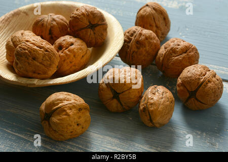 italian walnuts on the colored wooden table - closeup Stock Photo