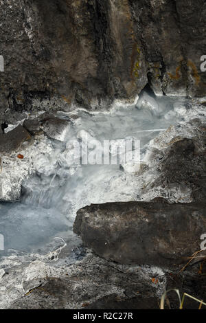 A close up vertical image of a sulpher spring and the opening in the mountain where it first comes out of the mountain in Jasper National Park Alberta Stock Photo