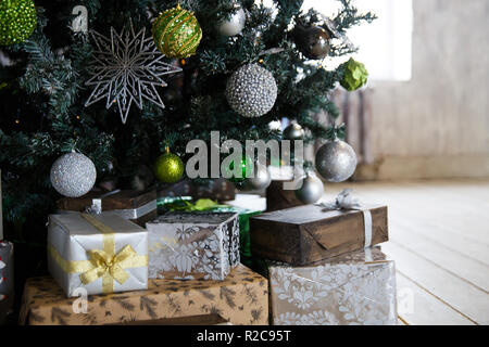 Gifts under the Christmas tree with decorations in the morning, the interior in vintage style Stock Photo