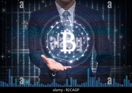 Businessman hand holding the bitcoins text financial technology or FINTECH connection over the digital number and trading graph background, Showing th Stock Photo
