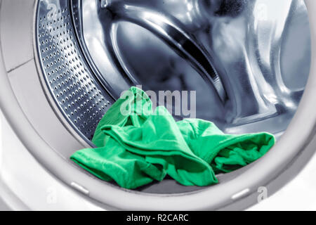 Clothes inside washing machine tube over white background Stock Photo