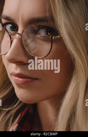 portrait of beautiful pensive woman in eyeglasses looking at camera Stock Photo