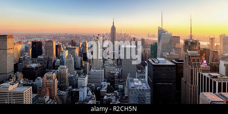 New York City. Manhattan downtown skyline with illuminated Empire State Building and skyscrapers at sunset. Stock Photo