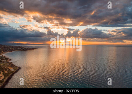 Glowing orange sunset over Port Phillip Bay near Mornington Peninsula coastline Stock Photo