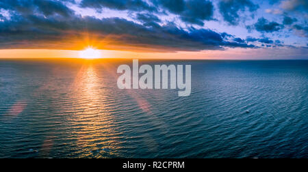 Lonely boat in wast ocean at sunset - wide aerial panorama Stock Photo