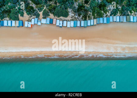Bathing boxes, sandy beach, and turquoise ocean water - aerial top view Stock Photo