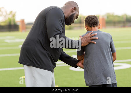 American Football coach training a young athlete. Stock Photo