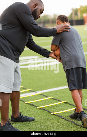 American Football coach training a young athlete. Stock Photo