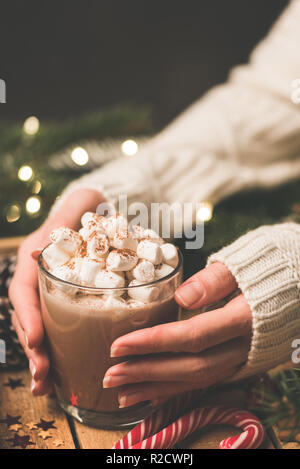 Woman holding mug of hot chocolate with marshmallows. Hot cocoa drink. Christmas, Winter holidays or New Year Comfort food, cozy background Stock Photo