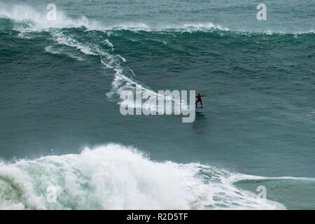 Nazare, Portugal. 18th Nov, 2018. Surfers tow in to giant waves at Portugal’s premier big wave spot Nazarè as a huge swells hit European coast line over the weekend Credit: Andy Bush/Alamy Live News Stock Photo