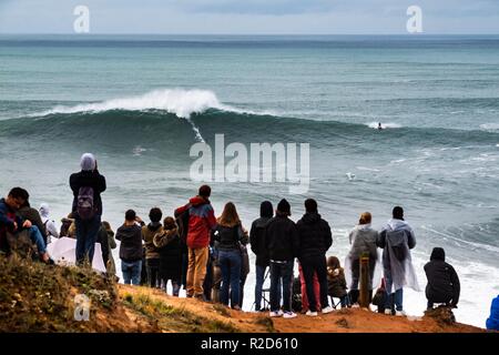 Nazare, Portugal. 18th Nov, 2018. Surfers tow in to giant waves at Portugal’s premier big wave spot Nazarè as a huge swells hit European coast line over the weekend Credit: Andy Bush/Alamy Live News Stock Photo