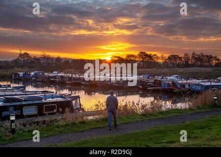 Rufford, Lancashire, UK. 19th Nov, 2018. UK Weather. Clear skies at the start of the day, with overnight temperatures of 5C, as dawn breaks over the Leeds Liverpool canal. Winds are now from the east with an icy blast expected. A cold morning for houseboat residents, who chose to live life afloat. St Mary's marina is home to many seasonal and long term boaters. With moorings for 100 craft up to 60 feet in length, it can accommodate both narrow and wide beam boats and canal cruisers. Credit: MediaWorldImages/Alamy Live News Stock Photo