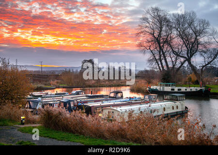 Rufford, Lancashire, UK. 19th November, 2018  UK Weather. Clear skies at the start of the day, with overnight temperatures of 5C, as dawn breaks over the Leeds Liverpool canal. Winds are now from the east with an icy blast expected. A cold morning for houseboat residents, who chose to live life afloat. St Mary's marina is home to many seasonal and long term boaters.  With moorings for 100 craft up to 60 feet in length, it can accommodate both narrow and wide beam boats and canal cruisers. Credit: MediaWorldImages/AlamyLiveNews Stock Photo