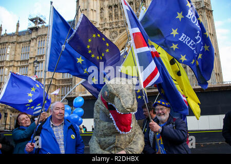 London, UK. 19th Nov, 2018. Pro-EU protesters holding flags are seen with a man wearing a large dinosaur costume during the protest.Pro-EU protesters from SODEM (Stand in Defiance European Movement) including a large dinosaur demonstrates with their placards and European Union flags outside the Palace of Westminster in central London ahead of the crucial week of Brexit negotiations as Prime Minister Theresa May prepares to meet Chief negotiator Michel Barnier later this week to discuss the withdrawal deal. Credit: Dinendra Haria/SOPA Images/ZUMA Wire/Alamy Live News Stock Photo