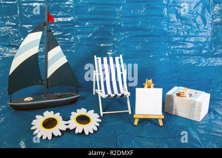 Summer Vacation Concept with toy boat with deck chair an Treasure chest on blue background Stock Photo