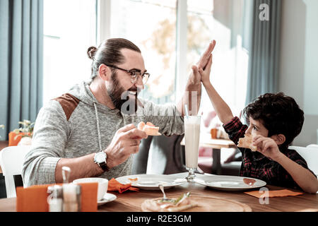 Father and son giving high five each other feeling happy together Stock Photo