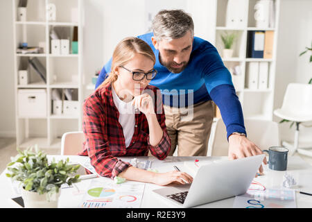 Concentrated programmers browsing internet while working on new  Stock Photo