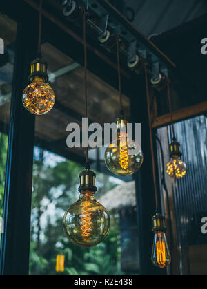 Decorative antique edison vintage style light bulbs on cafe background vertical style. Stock Photo