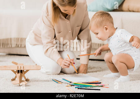 happy mother and adorable toddler drawing together in nursery room Stock Photo