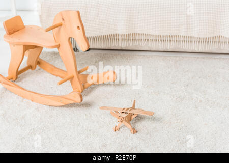 wooden horse and retro airplane toys on bedroom floor Stock Photo