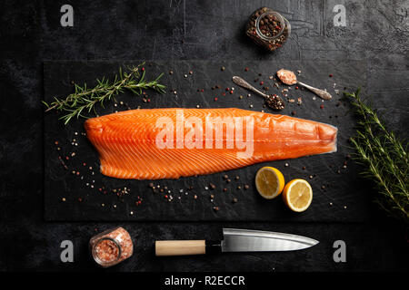 Big piece of Raw cut salmon fish set, on black dark stone table ...