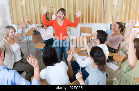 Portrait of delighted girl student with her groupmates and female teacher in university auditorium Stock Photo