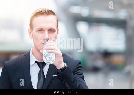 businessman holding water bottle drinking water refresh for business work day. Stock Photo