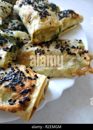 Cutted lavash pieces with vegetables. Burek with spinach and cheese and black cumin. Yufka Stock Photo