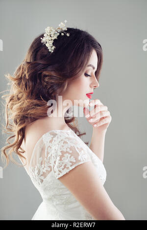 Charming woman fiancee looking down. Bridal hair, makeup and wedding dress  Stock Photo - Alamy