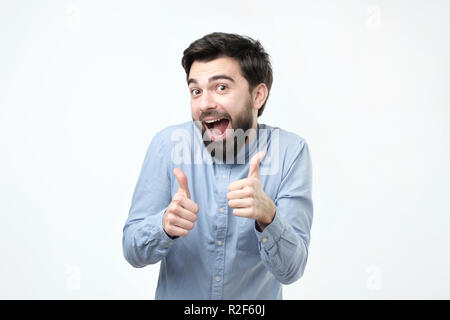 Smiling hispanic man showing both thumbs up and looking at camera. Stock Photo