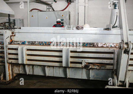 Special equipment for pressing paper waste at a waste sorting plant for further disposal or recycling. Stock Photo