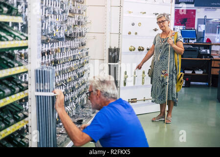 Senior adult couple in hardware shop together looking for and choosing stuffs to build or repair furnitures or other things at home. mature people  working and doing shoping together Stock Photo