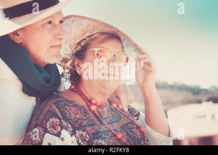 beautiful couple in love adult pamture people stay under the sun wuth hats for the shadow. vacation and nice lifestyle concept for man and woman Stock Photo