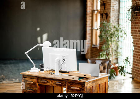 Beautiful working place with retro table, computers and lamp in the loft interior Stock Photo
