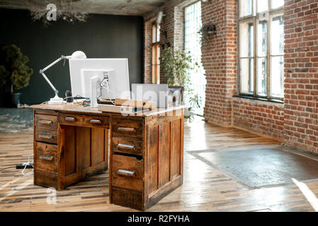 Beautiful working place with retro table, computers and lamp in the loft interior Stock Photo