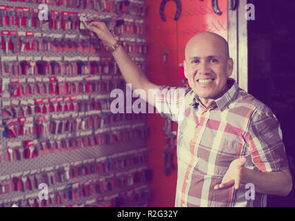 handyman posing with duplicates of door keys in workshop Stock Photo