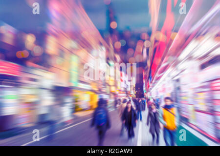 blur people in colorful shopping street walking at night life vivid city for background.