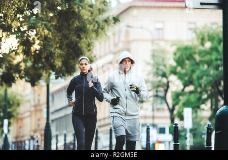 A fit couple running outdoors on the streets of Prague city. Stock Photo