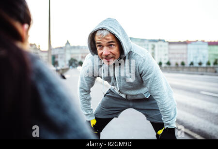 A fit couple runners stretching outdoors on the streets of Prague city. Stock Photo