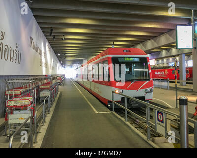 Zermatt, Switzerland - March 19, 2018: Railway station Zermatt with a train leaving to Täsch and a Glacier Express in the background Stock Photo