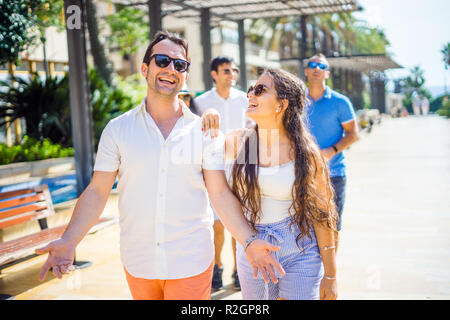 Pretty girl and handsome boy hanging out with friends in the city Stock Photo