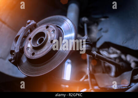 Car brake disk and caliper close up without wheel in cold colors with beautiful backlight Stock Photo