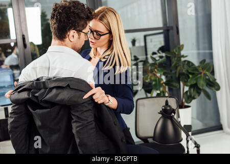 young businesswoman undressing colleague in office, flirting and office