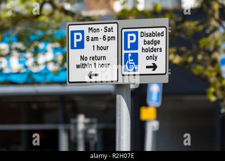 British parking restriction signs. No return within 1 hour and disabled badge holders only signs in the UK. Stock Photo